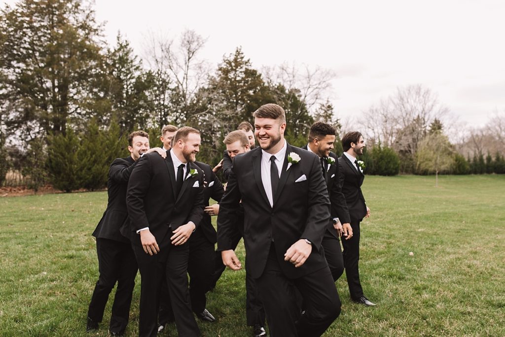 Groomsmen laughing with groom during photos
