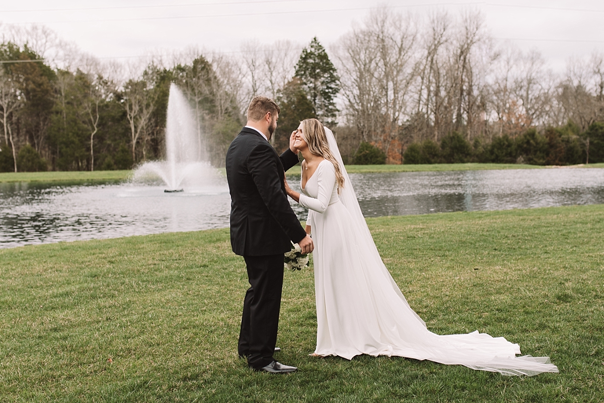Groom sharing a moment with the bride in front of the fountain at The Barn at Sycamore Farms