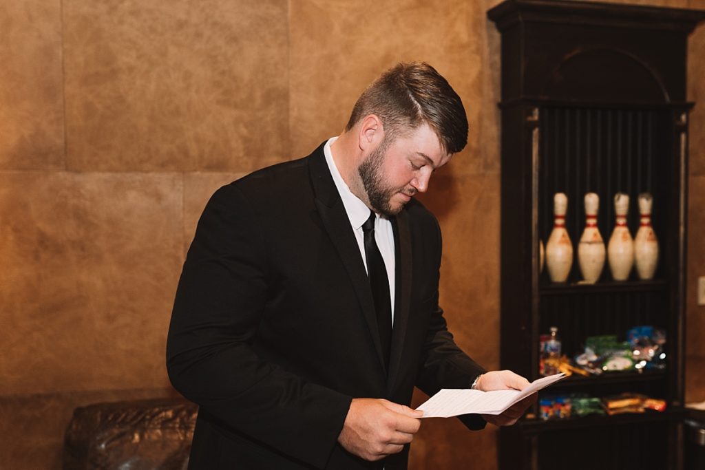 Groom reading letter from bride before their first look