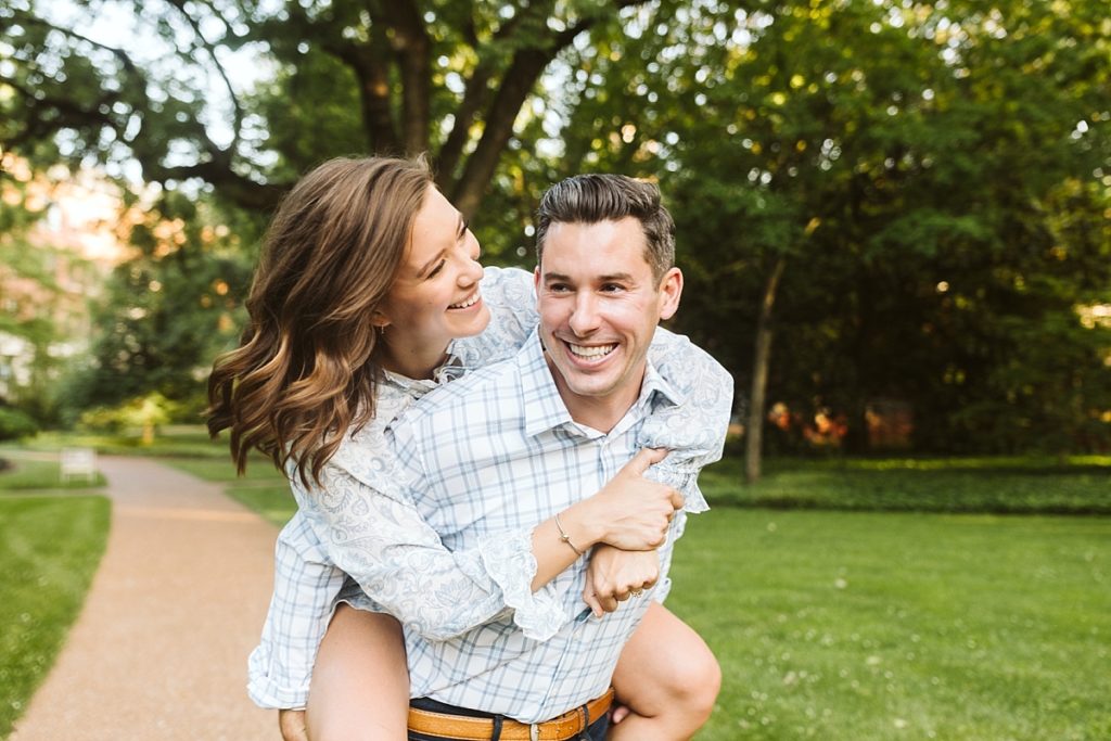 Groom giving his fiance a piggyback ride during engagement photos