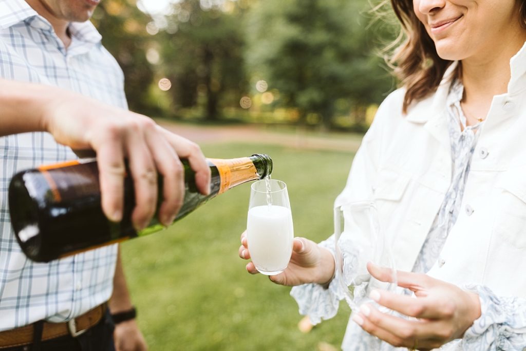 Couple pouring champagne for their engagement photos