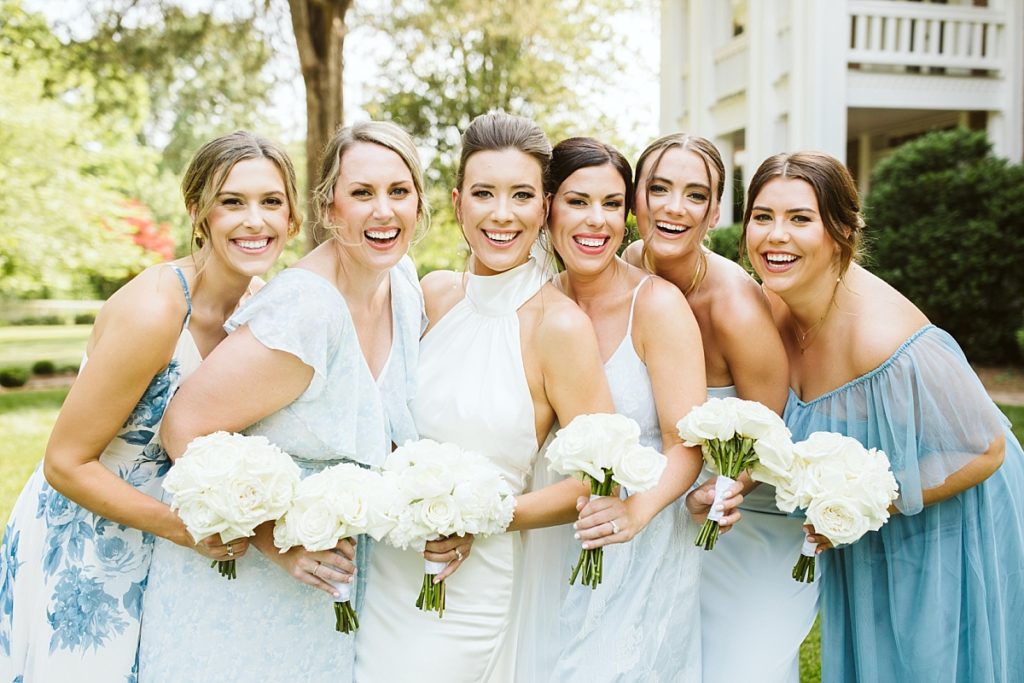 Close up photo of the bride with her bridesmaids holding white bouquets