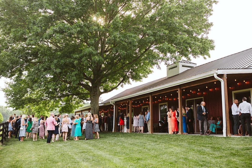 Photo of guests outside the barn at Cedarmont Farm for a garden party cocktail hour